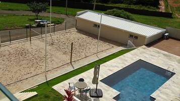 Un área de piscina en la azotea con un pequeño patio y una zona de estar cubierta.
