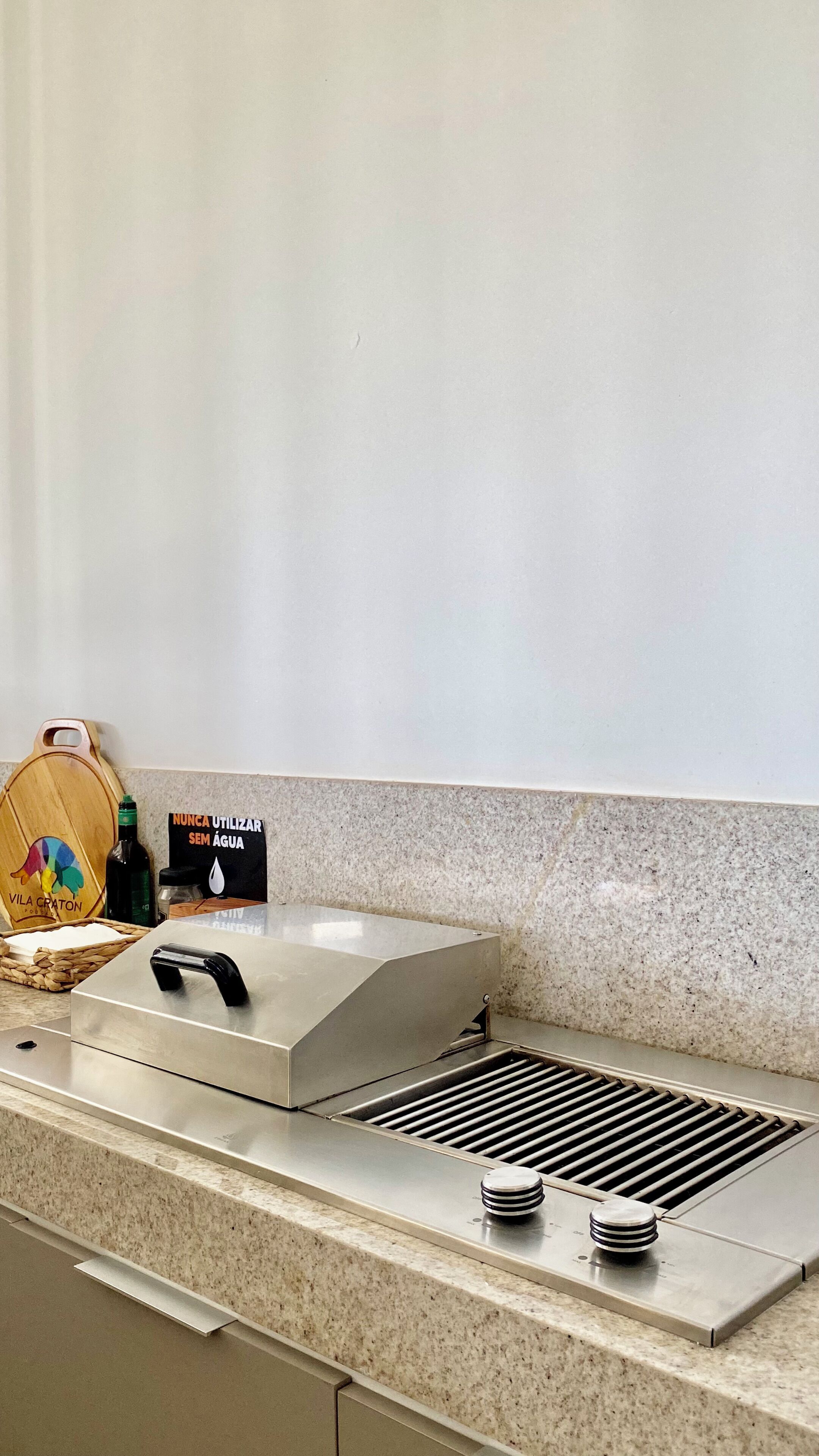Una cocina con campana de acero inoxidable, tabla de cortar de madera y un letrero que indica no usar agua.