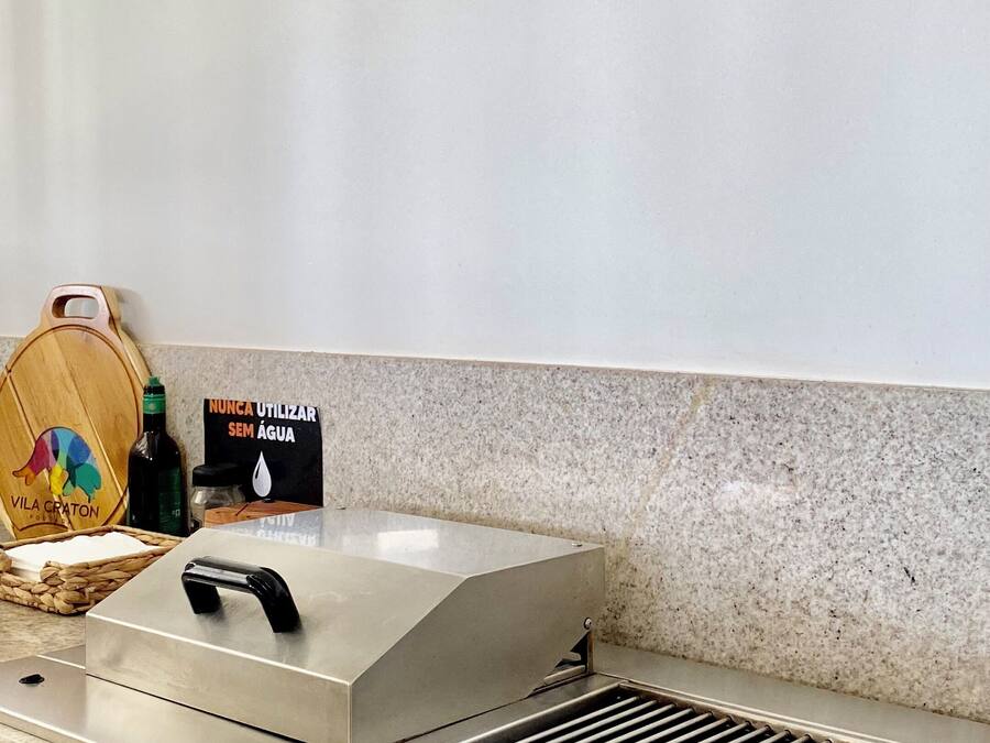 Una cocina con campana de acero inoxidable, tabla de cortar de madera y un letrero que indica no usar agua.