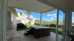 Ein moderner Außenbereich mit Whirlpool, einer Treppe und einer Glastür, die einen schönen Ausblick bietet.