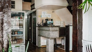 Una habitación de hotel compacta con una pequeña kitchenette, un refrigerador lleno de bebidas y piso de madera.