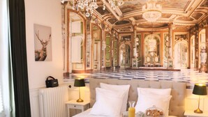 A luxurious hotel room with a large bed, a bathtub, and a chandelier. - La Marquise Cosy Flat - Jacuzzi - Senlis (Senlis)
