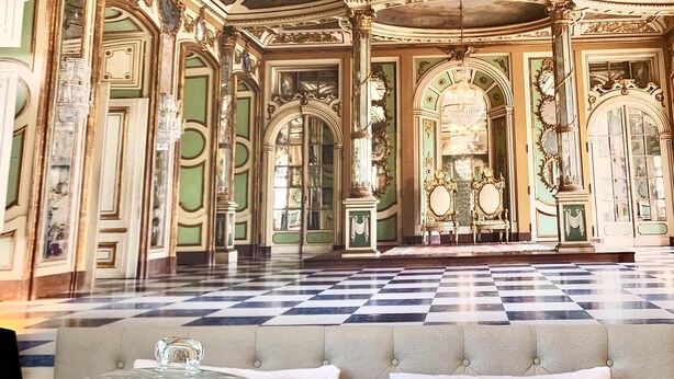 A breakfast setup with pastries on a glass dome, two glasses of orange juice, and a checkered floor in a grand room with ornate architecture. - La Marquise Cosy Flat - Jacuzzi - Senlis (Senlis)