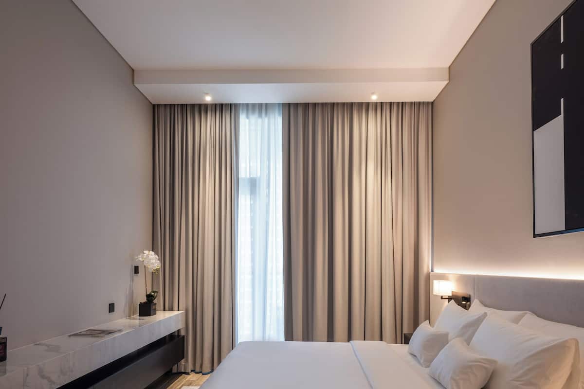 Relax in a serene space with a large bed, console table, and soft lighting.