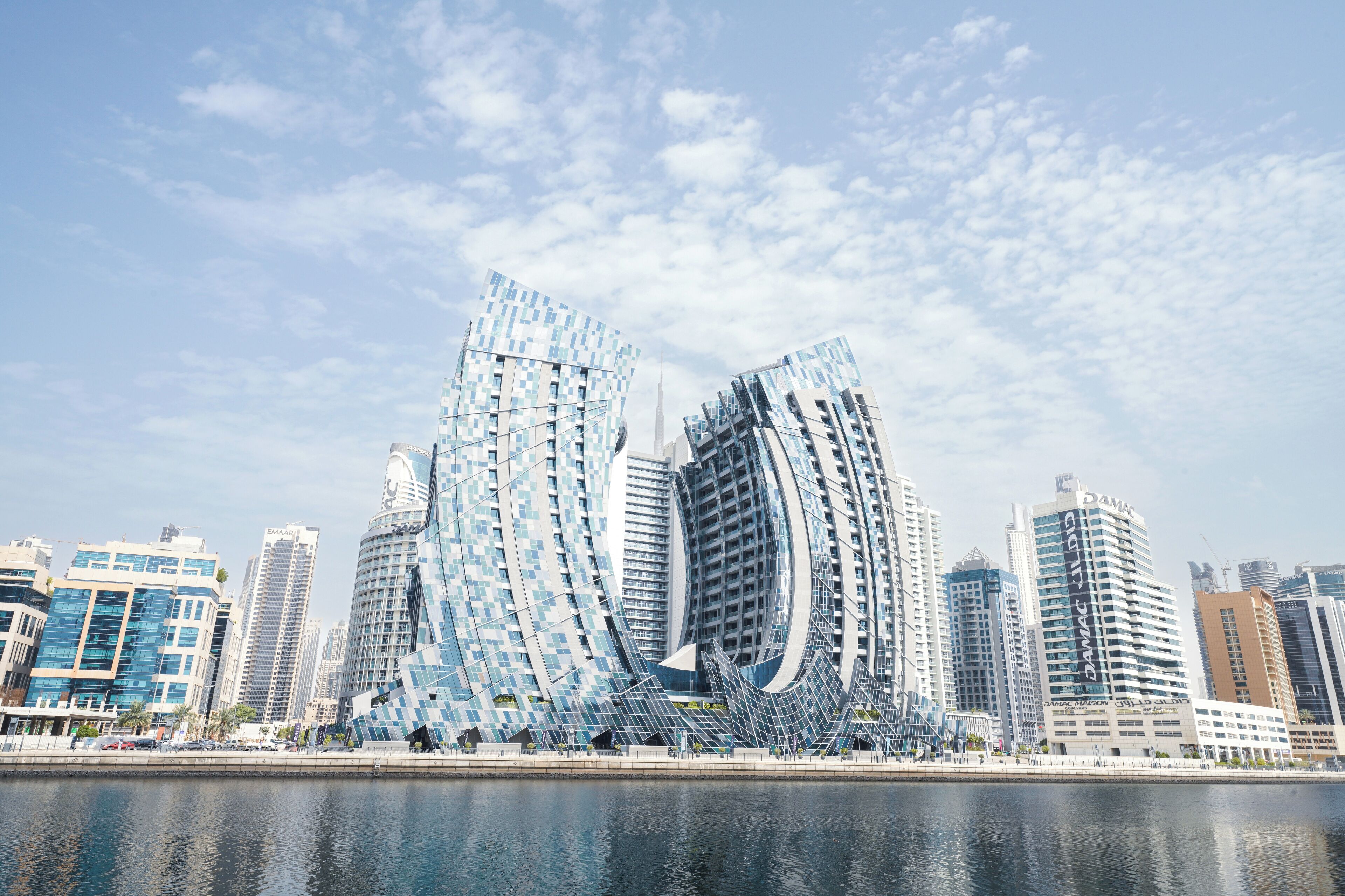 A modern cityscape with distinctive curved skyscrapers and a waterfront.