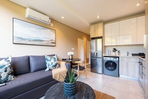 Una sala moderna con sofá, mesa de centro y un cuadro en la pared.