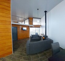 Uma sala de estar moderna com um sofá, uma televisão e uma lareira.