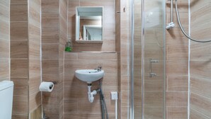 A bathroom with a sink, toilet, and shower. - Studio Unit in Chapel Market London (London)