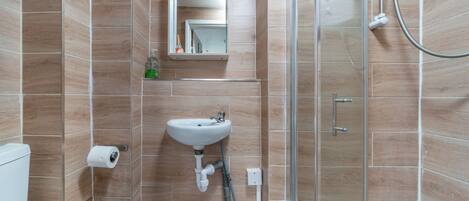 Une salle de bain avec un lavabo, des toilettes et une douche.