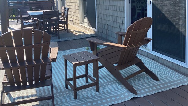 A covered patio with wooden deck, Adirondack chairs, and a table. - Spacious beach house with front and back yards, short walk to Scarborough beach  (Narragansett)