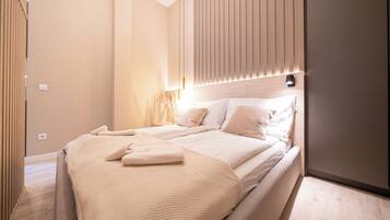 Un dormitorio moderno con una cama grande, una mesita de noche y una lámpara de pared.