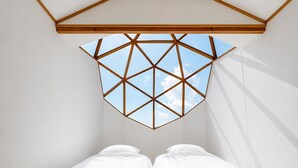 A room with a geometric skylight, a bed with white bedding, and a wooden ceiling structure. - HOLE37 (Tsukuba)