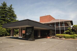 A modern building with a covered entrance and a sign reading 'TSUKUBA KOKUSAI COUNTRY CLUB'. - HOLE37 (Tsukuba)