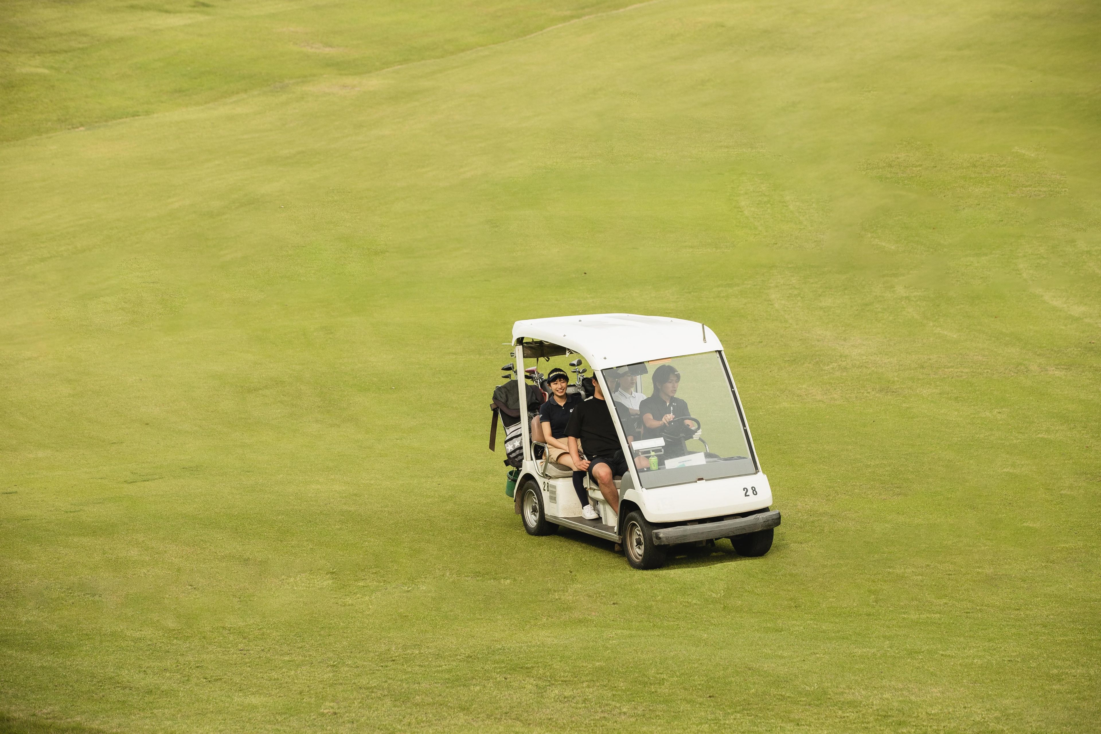 A golf cart on a green field.