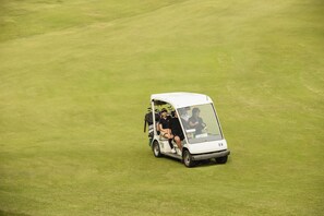 En golfbil på en grøn mark.
