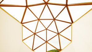 A geometric ceiling design with a view of a green landscape through a window. - HOLE37 (Tsukuba)