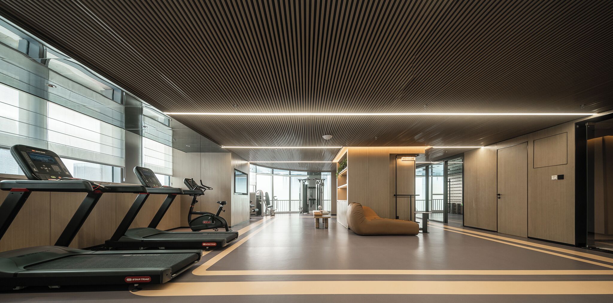 A modern gym with treadmills, exercise bikes, and a large mirror.