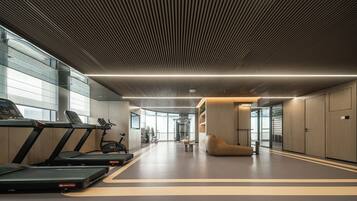 A modern gym with treadmills, exercise bikes, and a large mirror.