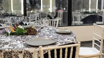 A dining table set with wine glasses, plates, and a centerpiece.