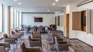 A conference room with a long table, multiple chairs, and a large screen. - Novotel México City Centro Histórico (Mexico City)