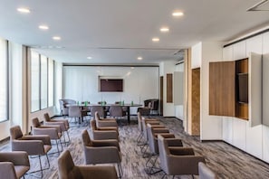A conference room with a long table, multiple chairs, and a large screen. - Novotel México City Centro Histórico (Mexico City)