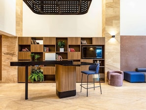 A modern lobby with a bar area, seating, and a TV. - Novotel México City Centro Histórico (Mexico City)