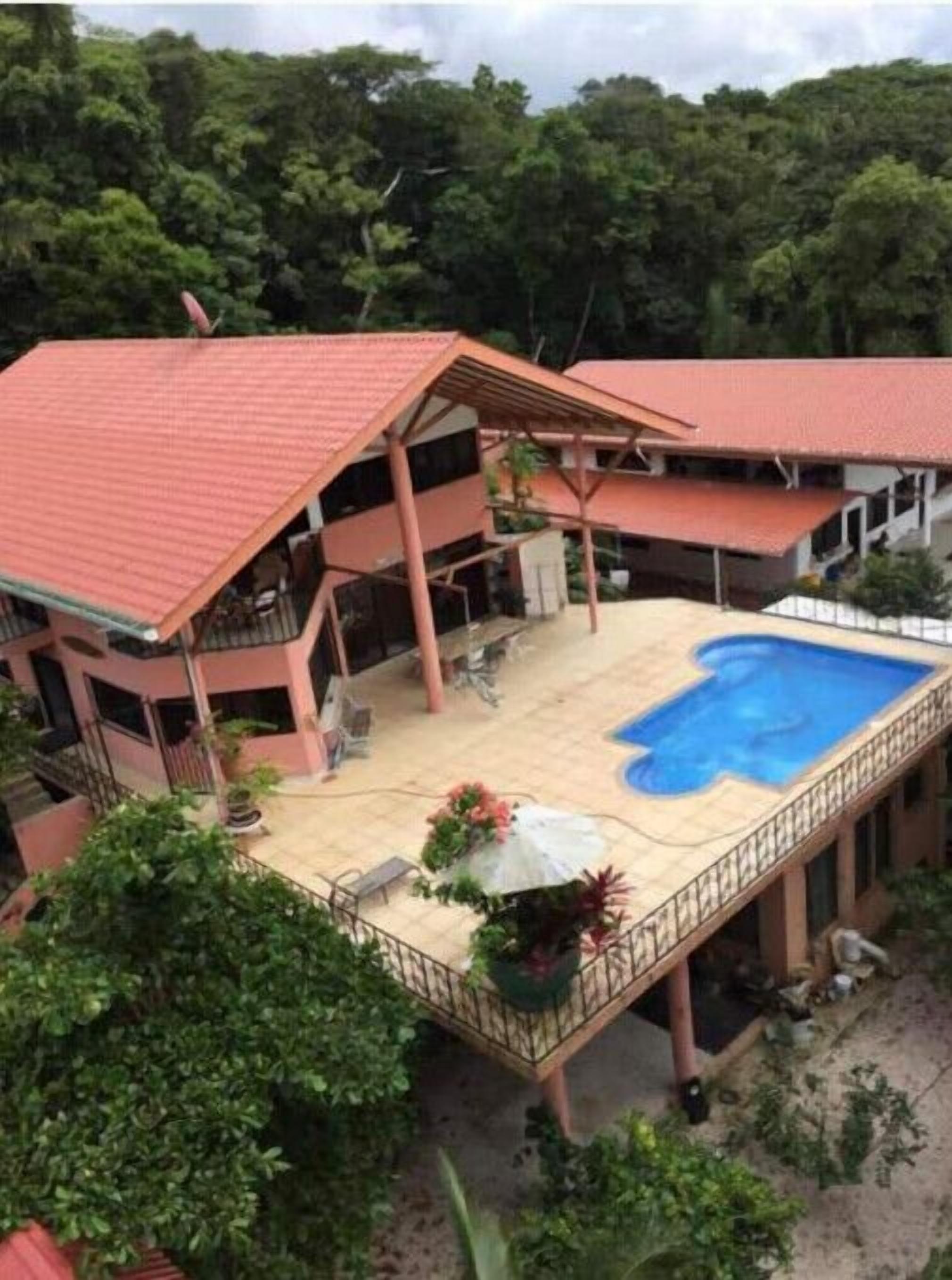 Um edifício de dois andares com piscina no andar térreo.