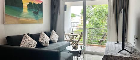Un salon moderne avec un canapé, une petite table et un tableau accroché au mur.