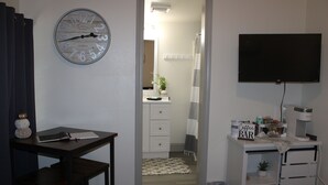 A room with a desk, a clock, a TV, and a coffee bar. - Allie Rose/ Cabin 2 Lake Athens/ Canton Trade Days (Athens)