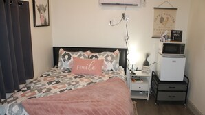 A bedroom with a bed, a nightstand, a dresser, a microwave, and a small refrigerator. - Allie Rose/ Cabin 2 Lake Athens/ Canton Trade Days (Athens)