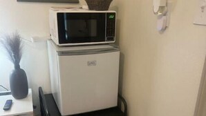 A compact kitchenette with a microwave and a mini-fridge stacked on a black cart. - Allie Rose/ Cabin 2 Lake Athens/ Canton Trade Days (Athens)