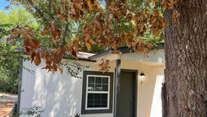 A small, single-story building with a white exterior and a dark door. - Allie Rose/ Cabin 2 Lake Athens/ Canton Trade Days (Athens)