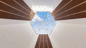 A modern interior with a geometric glass ceiling structure. - Brit Hotel Privilège Paris - Rosny (Rosny-sous-Bois)