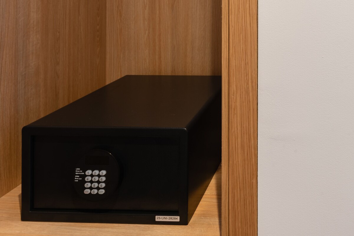 A black electronic device with a keypad, a wooden hanger rack, and two card readers on a wall.