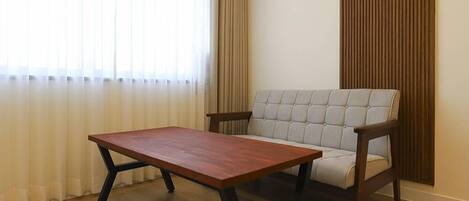 A room with a wooden table and a cushioned chair.