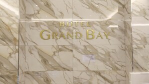A hotel sign with the name "HOTEL GRAND BAY" in gold lettering on a marble background. - Hotel Grand Bay Boryeong (Boryeong)