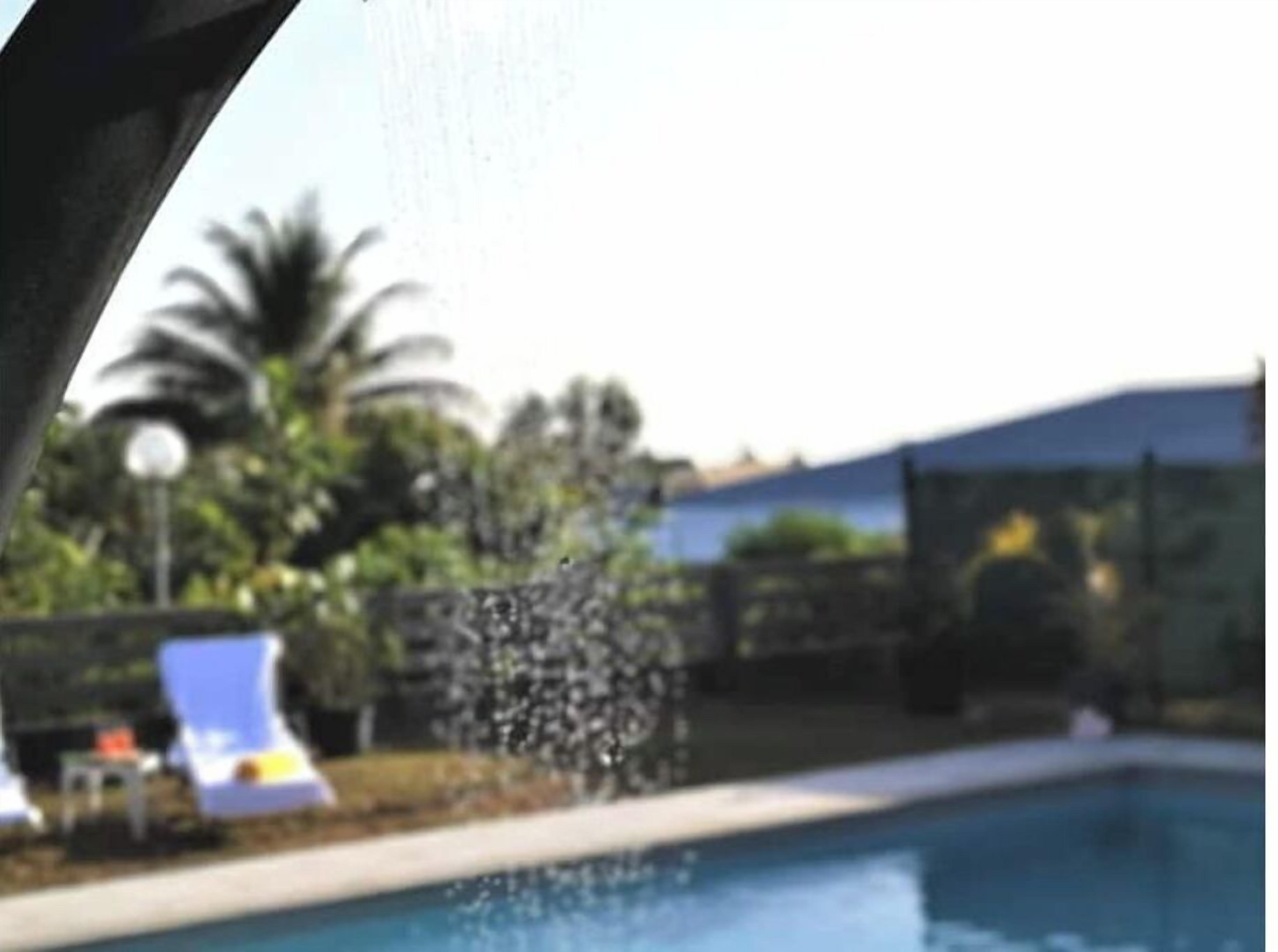 En swimmingpool med liggestole og et vandfald.