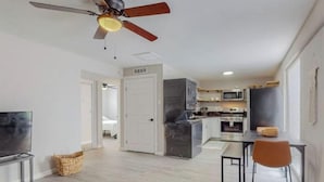 A modern apartment with a kitchen, dining area, and a living room.