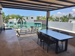 A covered outdoor area with a table and chairs, a view of buildings, and a clear sky. - Elegant big House Nvo Vta (Nuevo Nayarit)