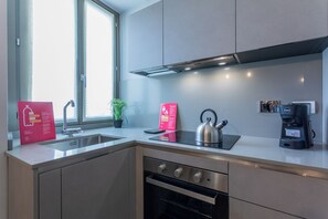 Familie appartement | Privékeuken | Een koelkast met diepvriezer, een oven, een kookplaat