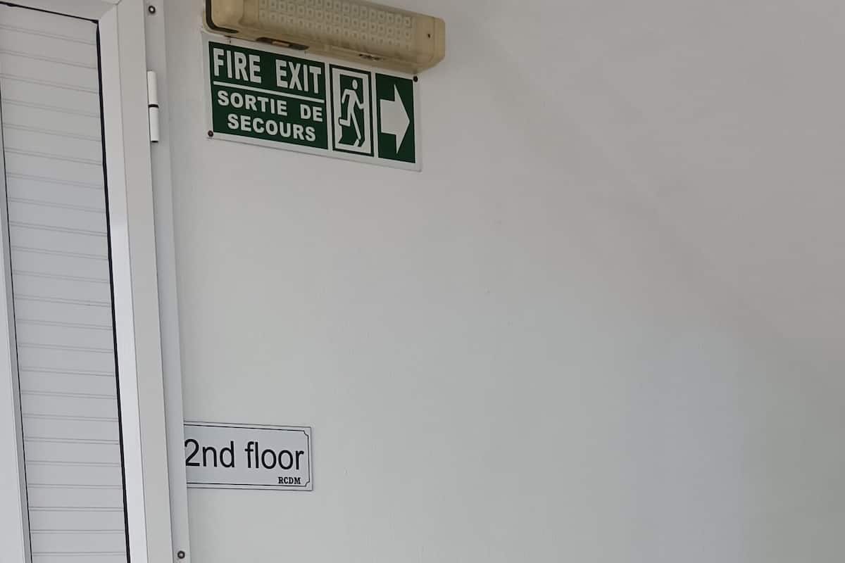 A fire exit sign, a 2nd floor sign, and a door.