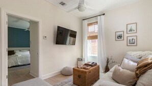 Ein modernes Wohnzimmer mit einer Couch, einem Couchtisch und einem an der Wand befestigten Fernseher.
