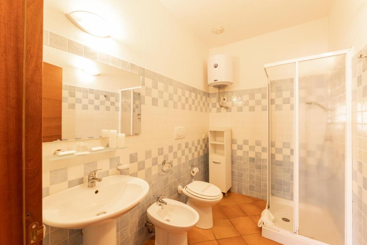 Une salle de bain équipée d’un lavabo, d’un bidet, de toilettes et d’une douche à parois de verre.