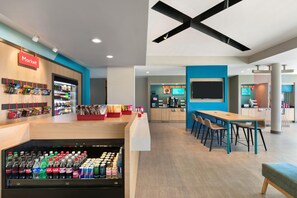 Un espacio interior moderno con zona de mercado, zona de estar y mostrador.
