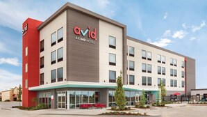 A modern hotel with a prominent 'avid' sign, large windows, and a covered outdoor seating area. - Avid Hotel Traverse City By IHG (Traverse City)