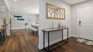 A modern interior with a dining area, a console table, and a white door.