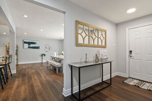 A modern interior with a dining area, a console table, and a white door.