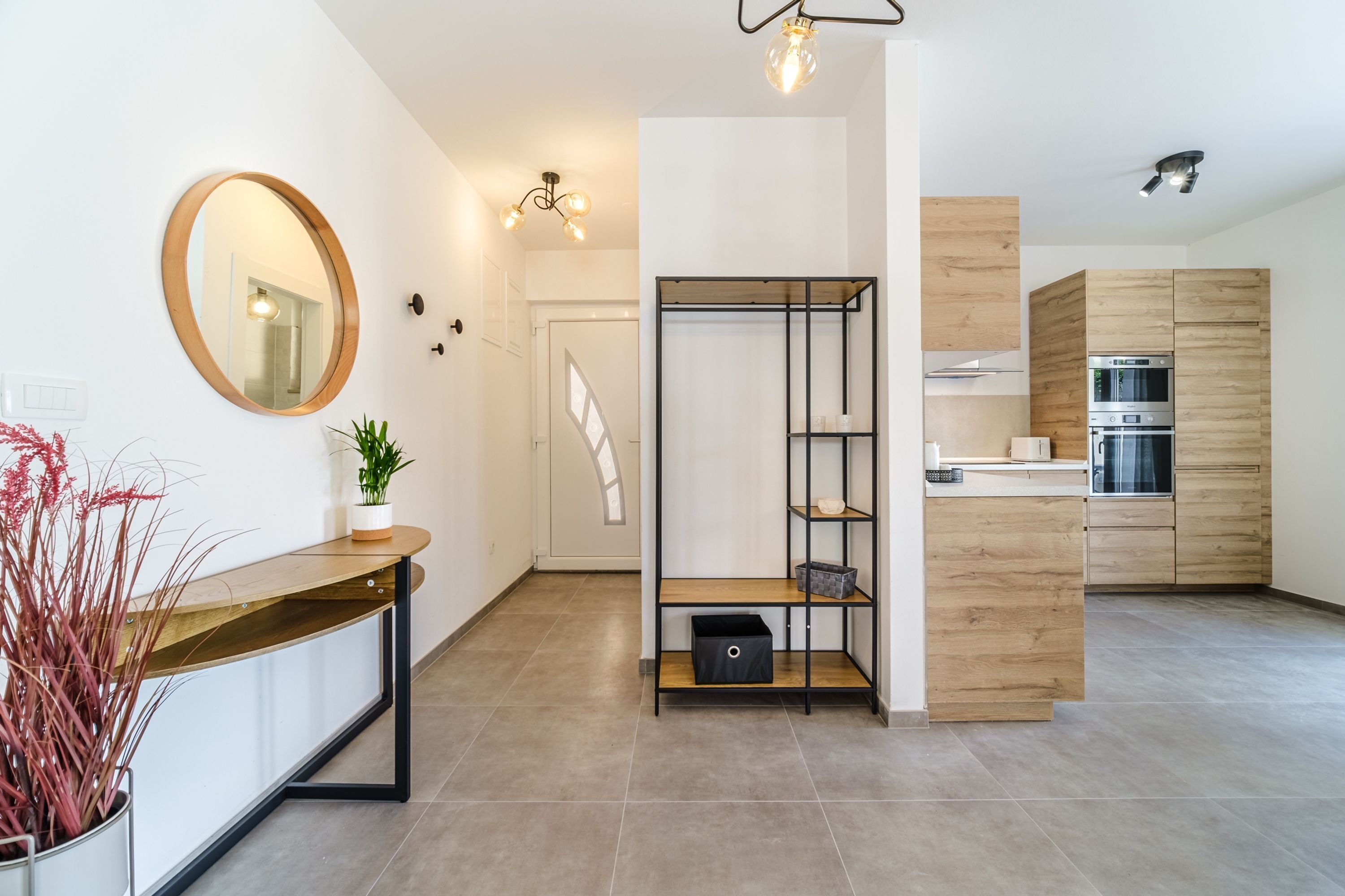 Une cuisine moderne avec des meubles en bois, un four encastré et un plan de travail.