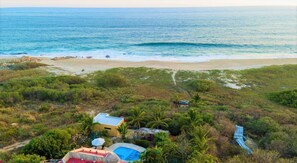 Ein Küsteneigentum mit Pool, Strand und einem Weg zum Meer.