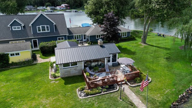 Une maison dotée d’un patio, d’un espace salon extérieur et offrant une vue sur un lac.